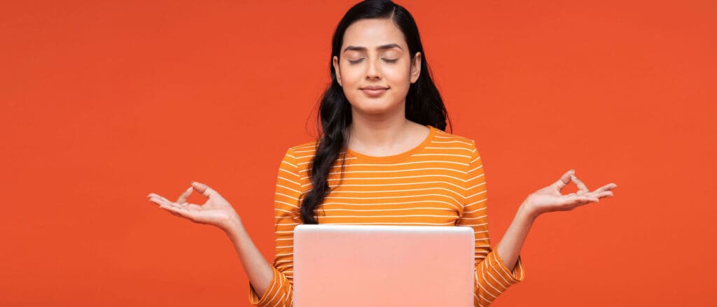 Woman Meditating with laptop on lap