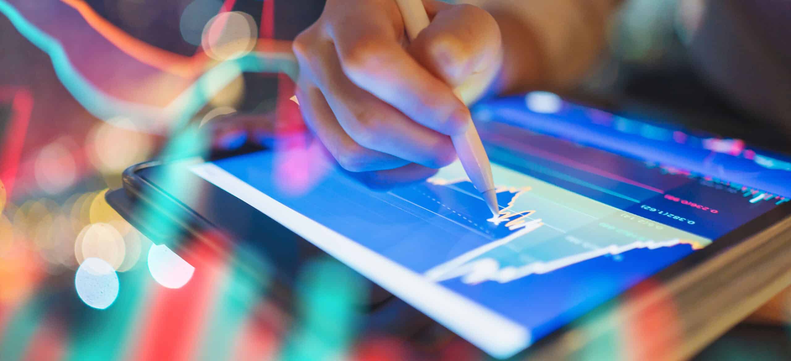 Person using stylus on tablet with finance information