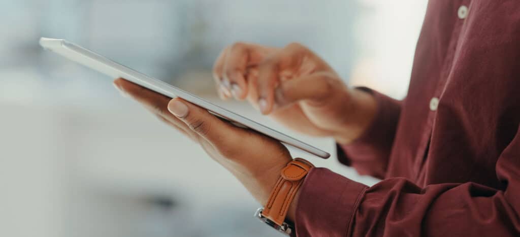 Close-up of a person wearing a watch working on a tablet