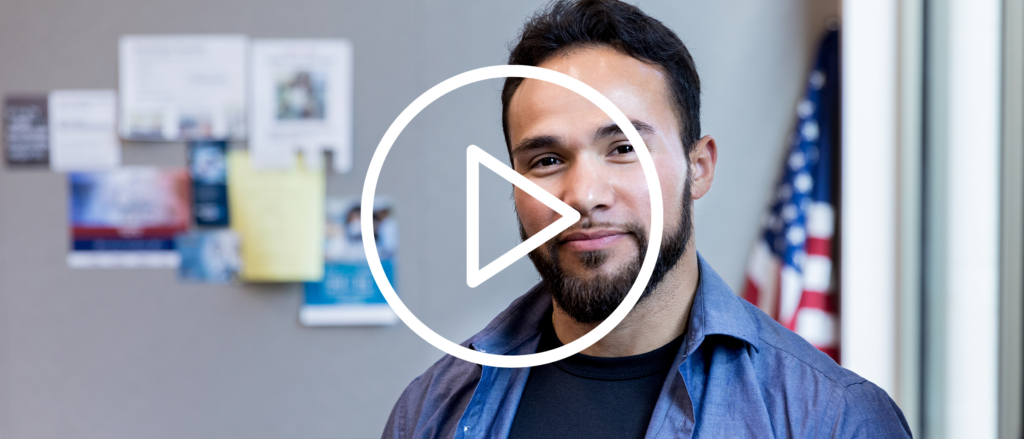 VET Smiling at camera, with video play button overlaid on image