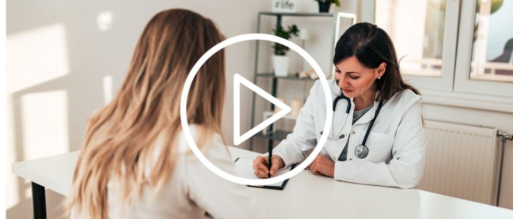 Nurse practitioner wearing a stethoscope taking notes for a patient at a visit