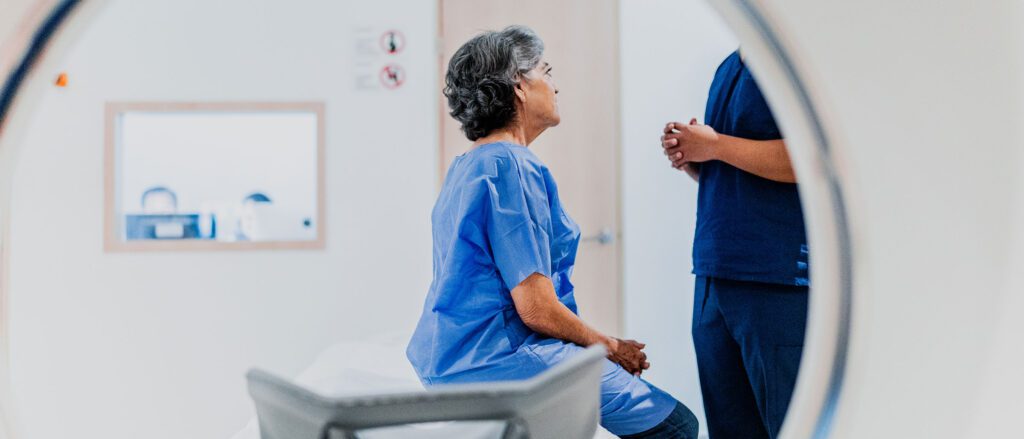 Woman sitting on an examination table being consulted by a medical professional