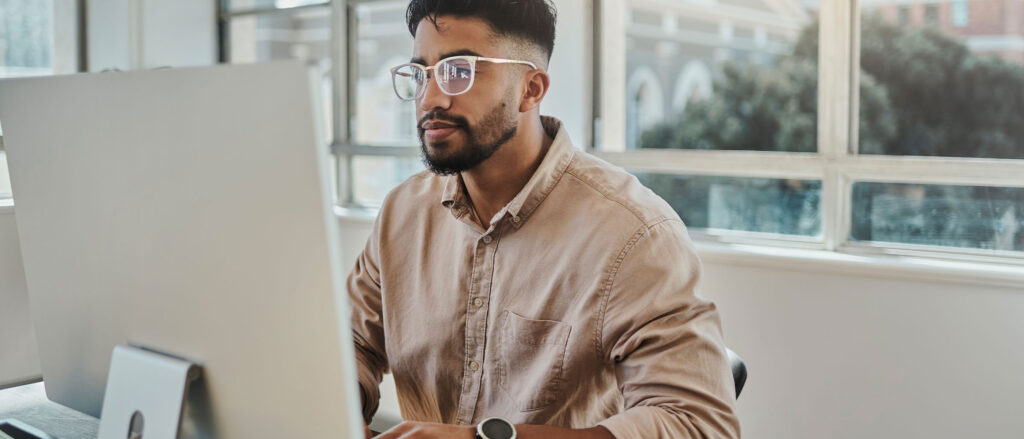 Man sitting at desk typing on computer