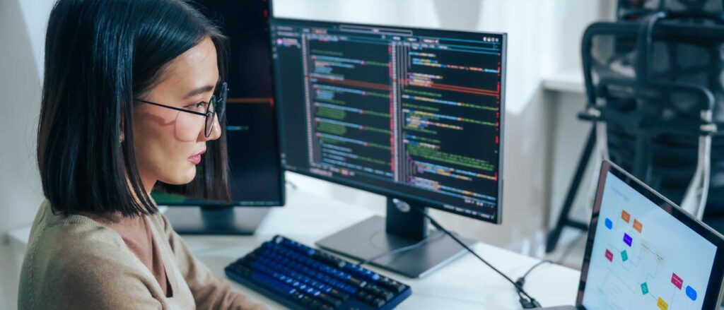 Software engineer looking and a monitor displaying code