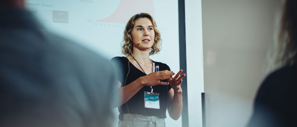 Facilitated Learning Speaker standing in front of a room, giving a presentation