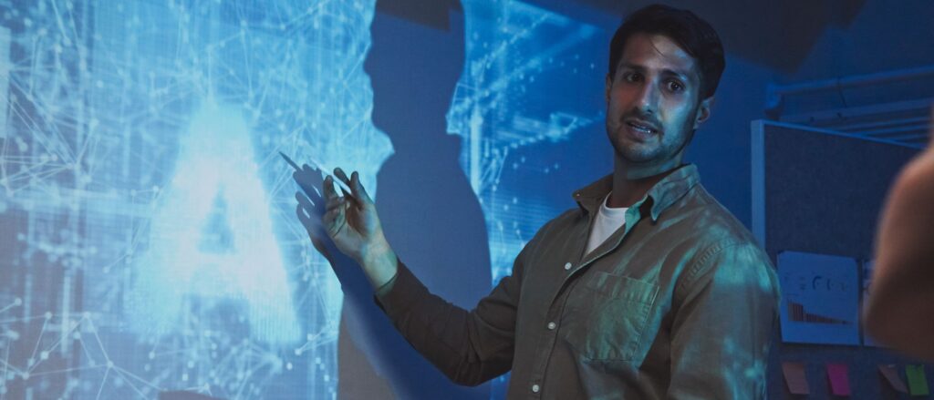 Man pointing at projected image on a wall with AI being shown