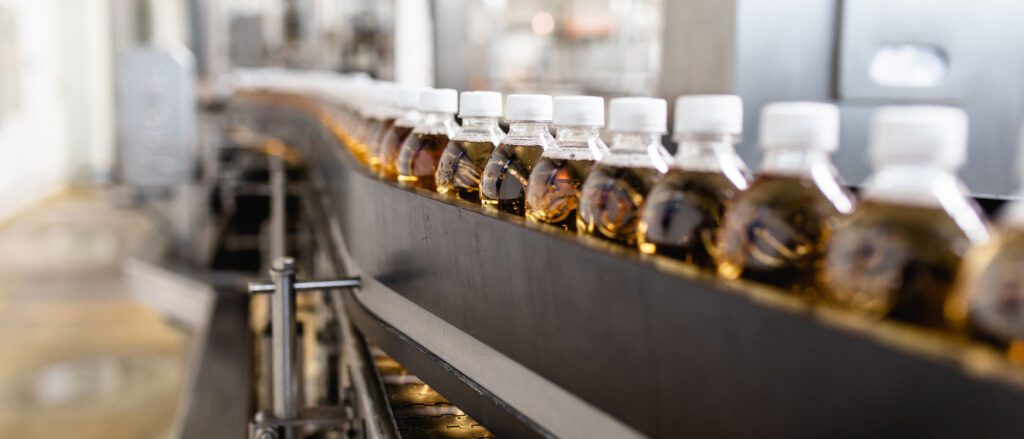 Line of juice in plastic bottles moving on on conveyor belt