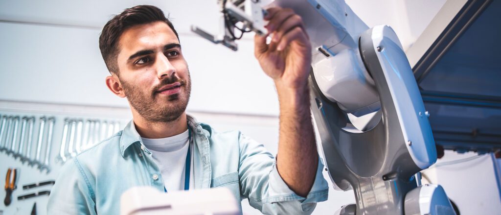 Man adjusting the placement of robotic arm