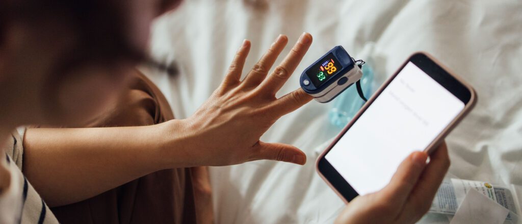 Photo of a womans hand with a heart rate reader on her pointer finger