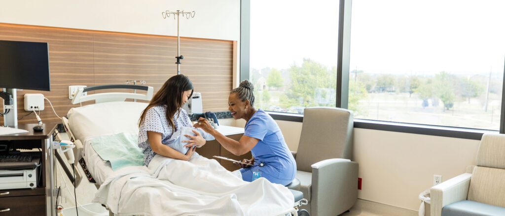 Healthcare professional helping a girl laying in hospital bed