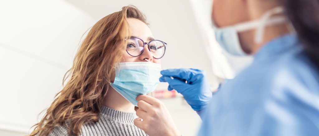 Woman having her nose swabbed by a medical professional