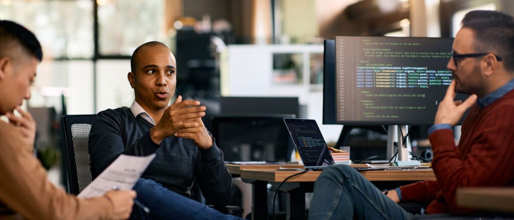 Group of engineers sitting around each other talking