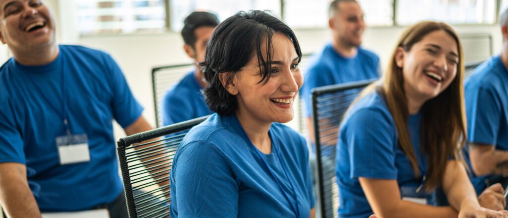 Room full of people sitting on chairs, smiling