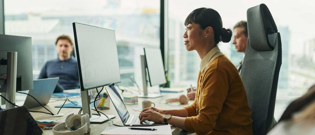 Woman typing on laptop working on SaaS Implementation