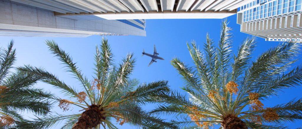 Photo taken from the ground, looking up at a plane in the sky