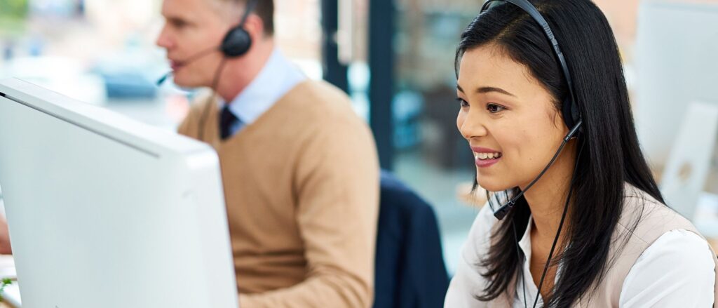 Woman wearing a headset with microphone looking at a monitor