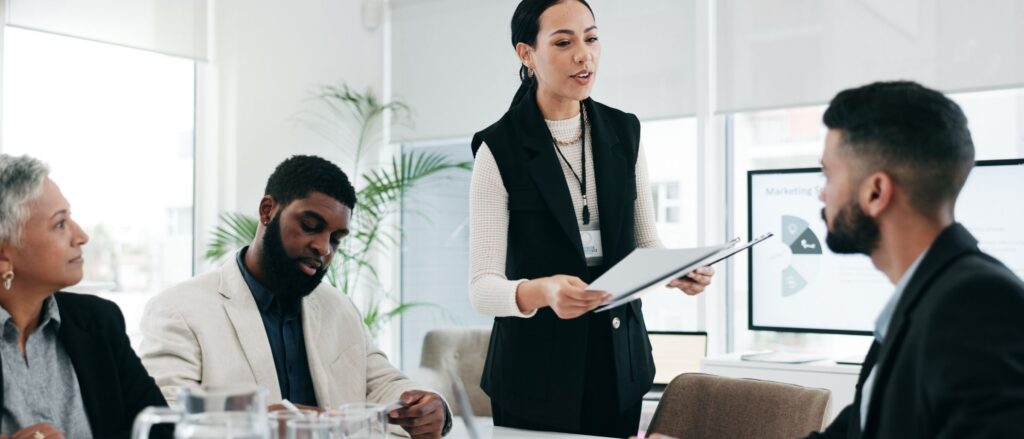 Woman holding papers in conference room discussing leadership plans